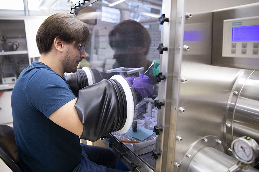 A student works in a glove box in the chemistry lab.