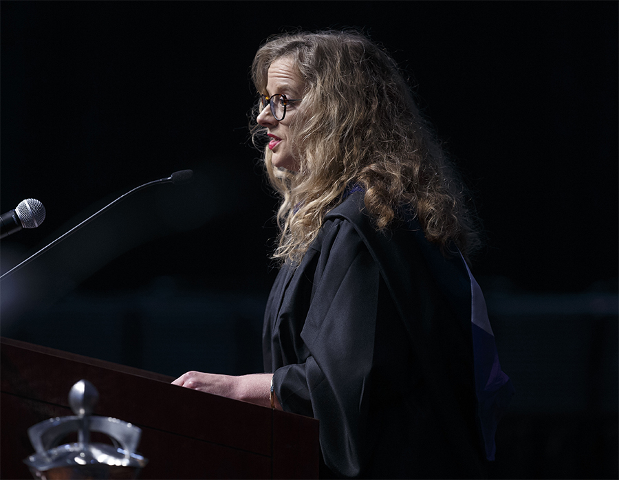 Katie Kuznacic speaks at a podium during commencement.