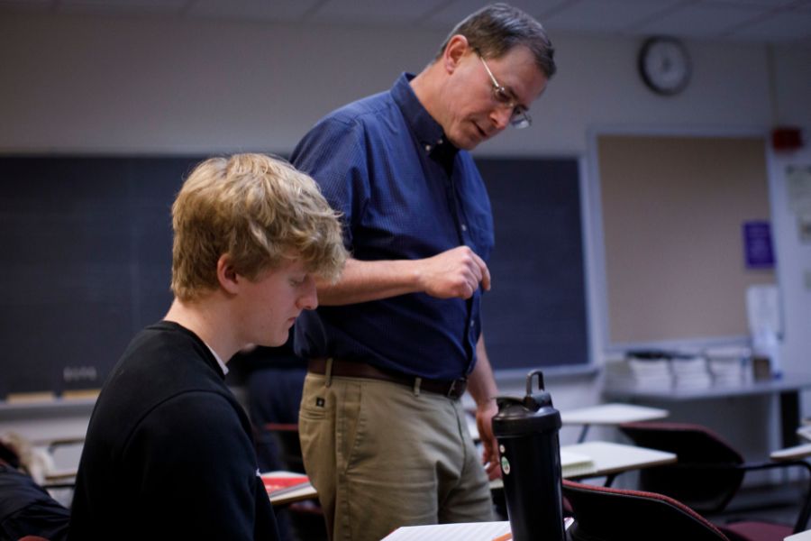 Professor is looking at student's work.