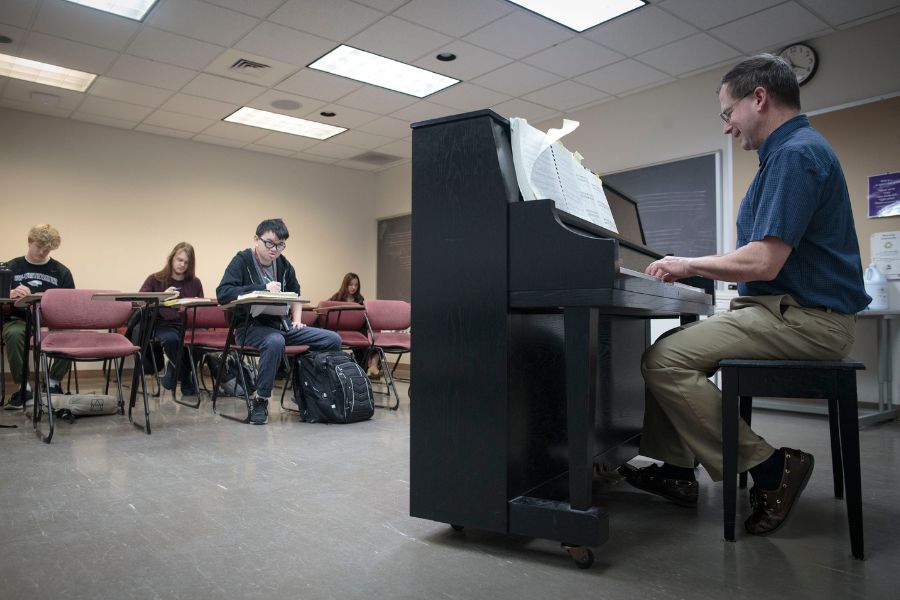 Professor is playing piano in class.