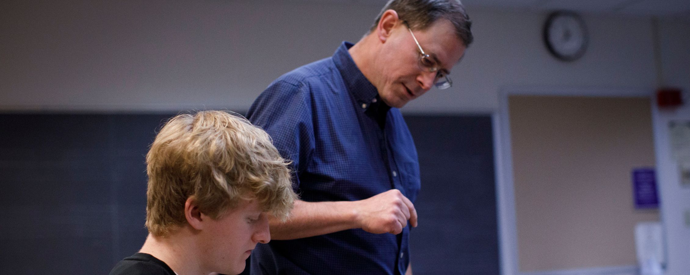 Professor looks over at student work.