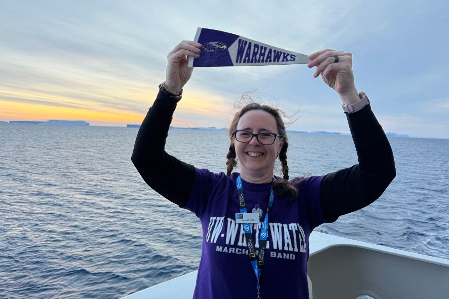 Lisa Warner holding UW-Whitewater pennant.