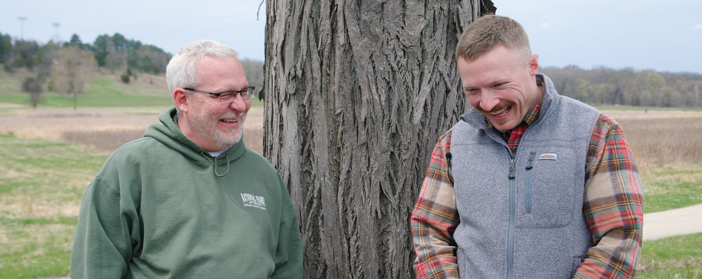 Tyler smiles against the tree.