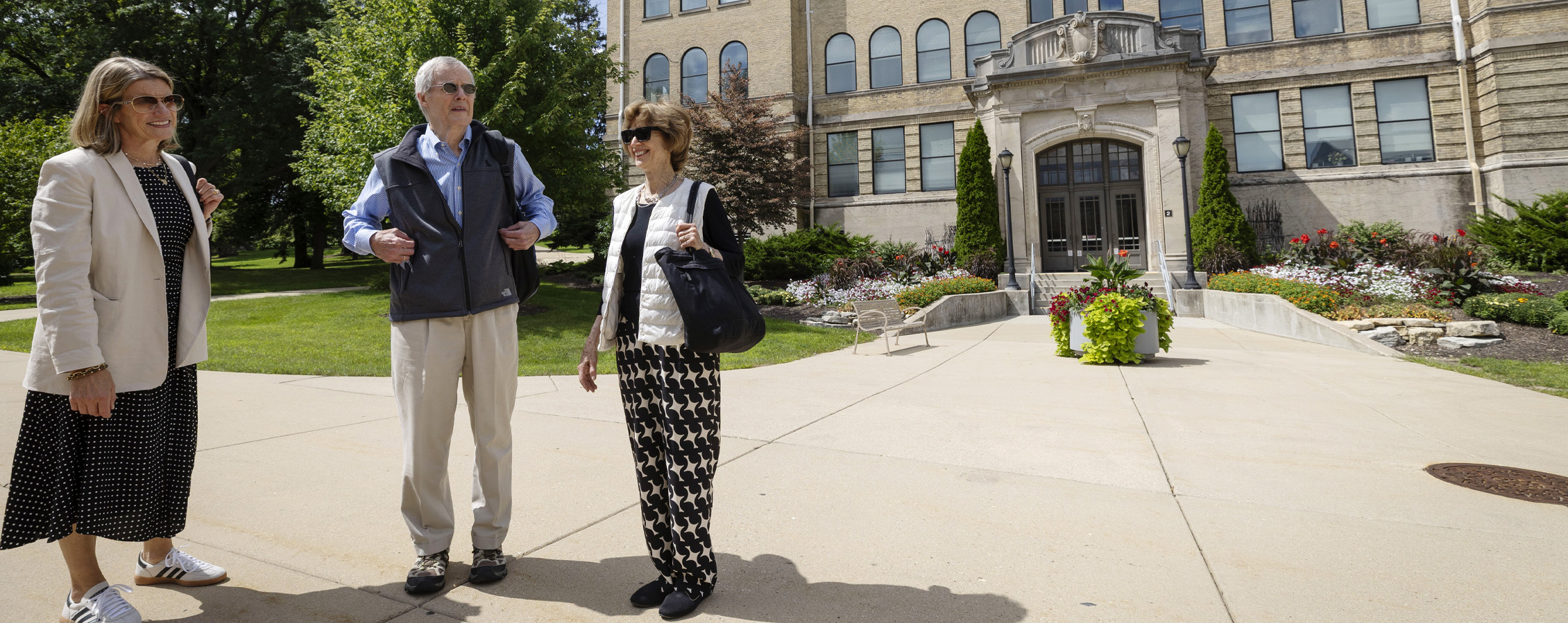 Three people stand outside of Hyer Hall.