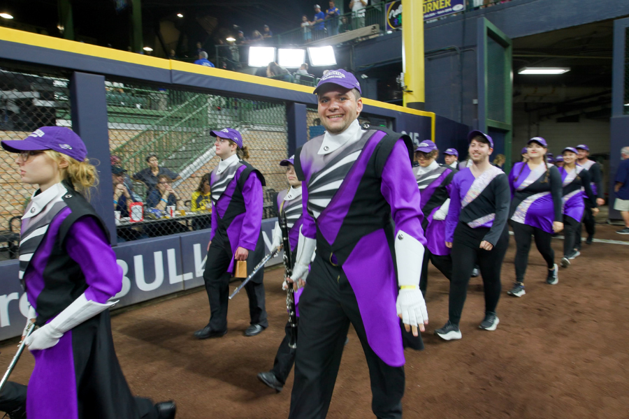 Student smiles while walking into the American Family Field for Marching Band Performance.