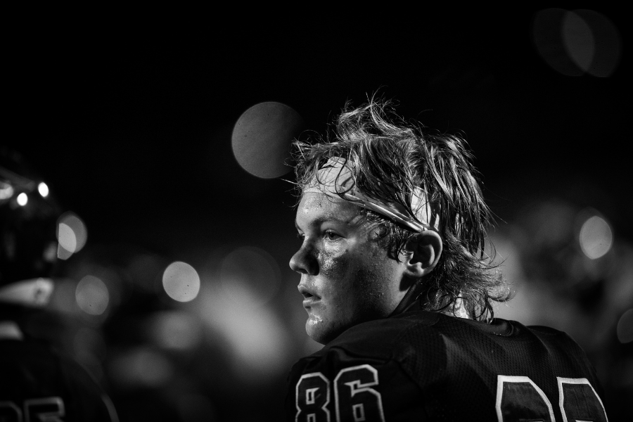 Student athlete looks ahead during football game.