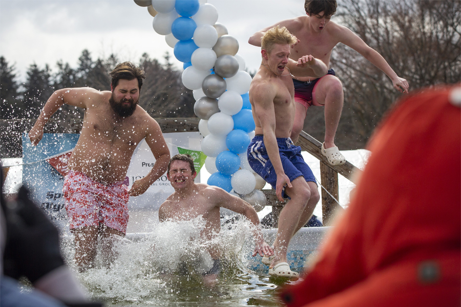 Four guys jump into the pool for Polar Plunge.