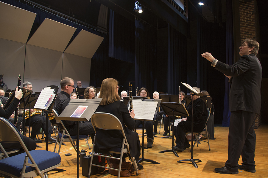 Jeff Suarez stands and conducts a band.