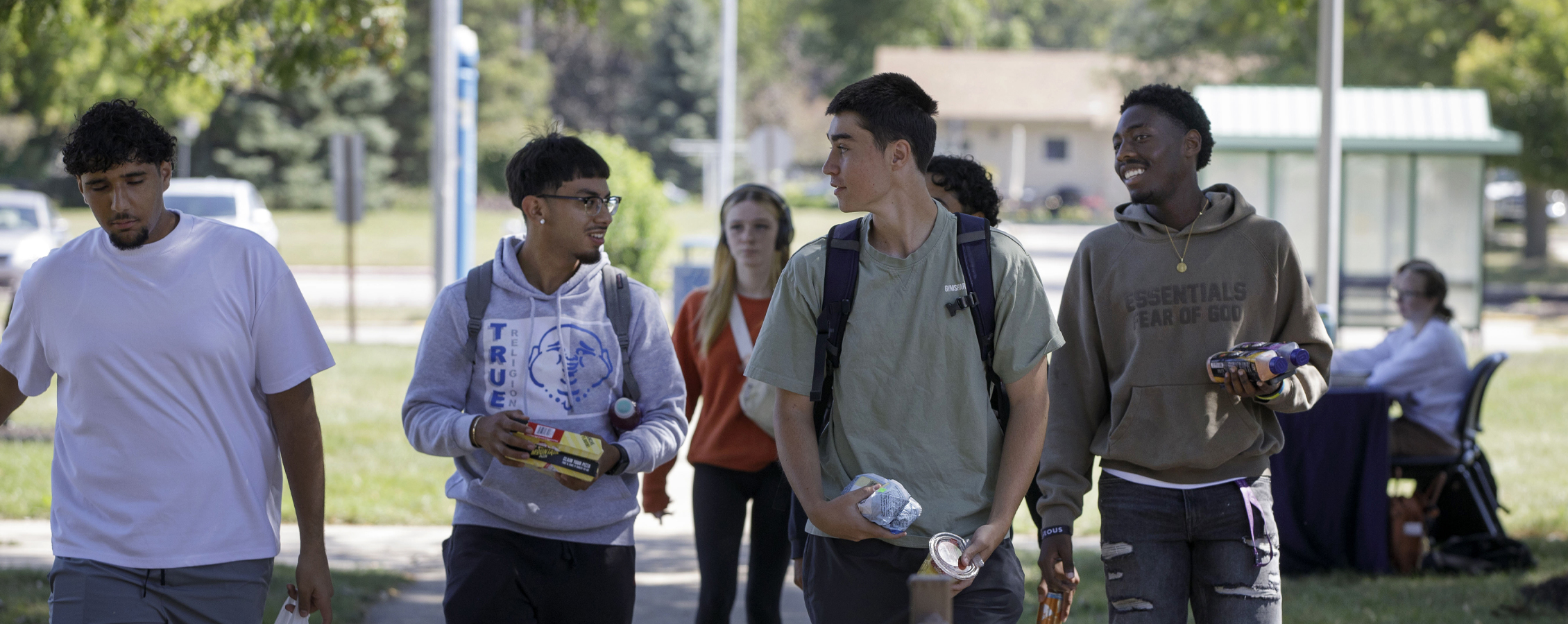 A group of students walk down a sidewalk together.