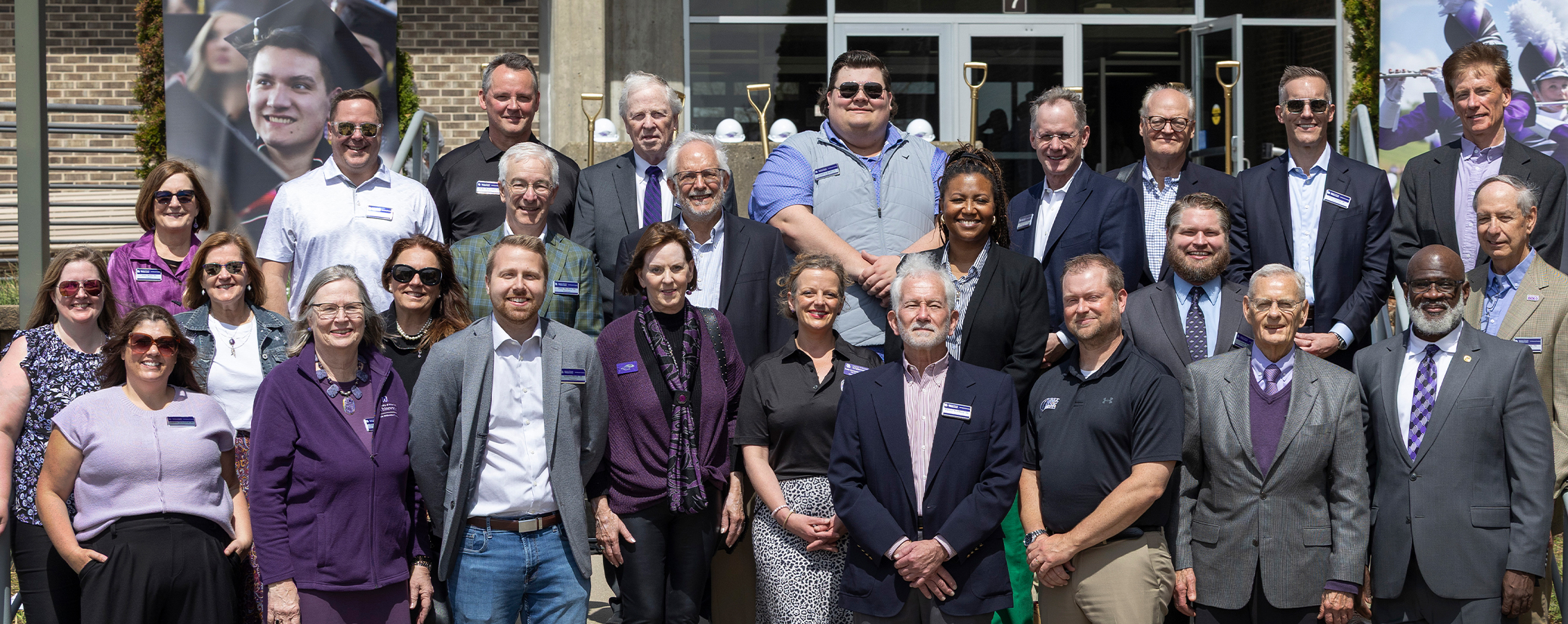 A large group of people stand together and pose for a photo.